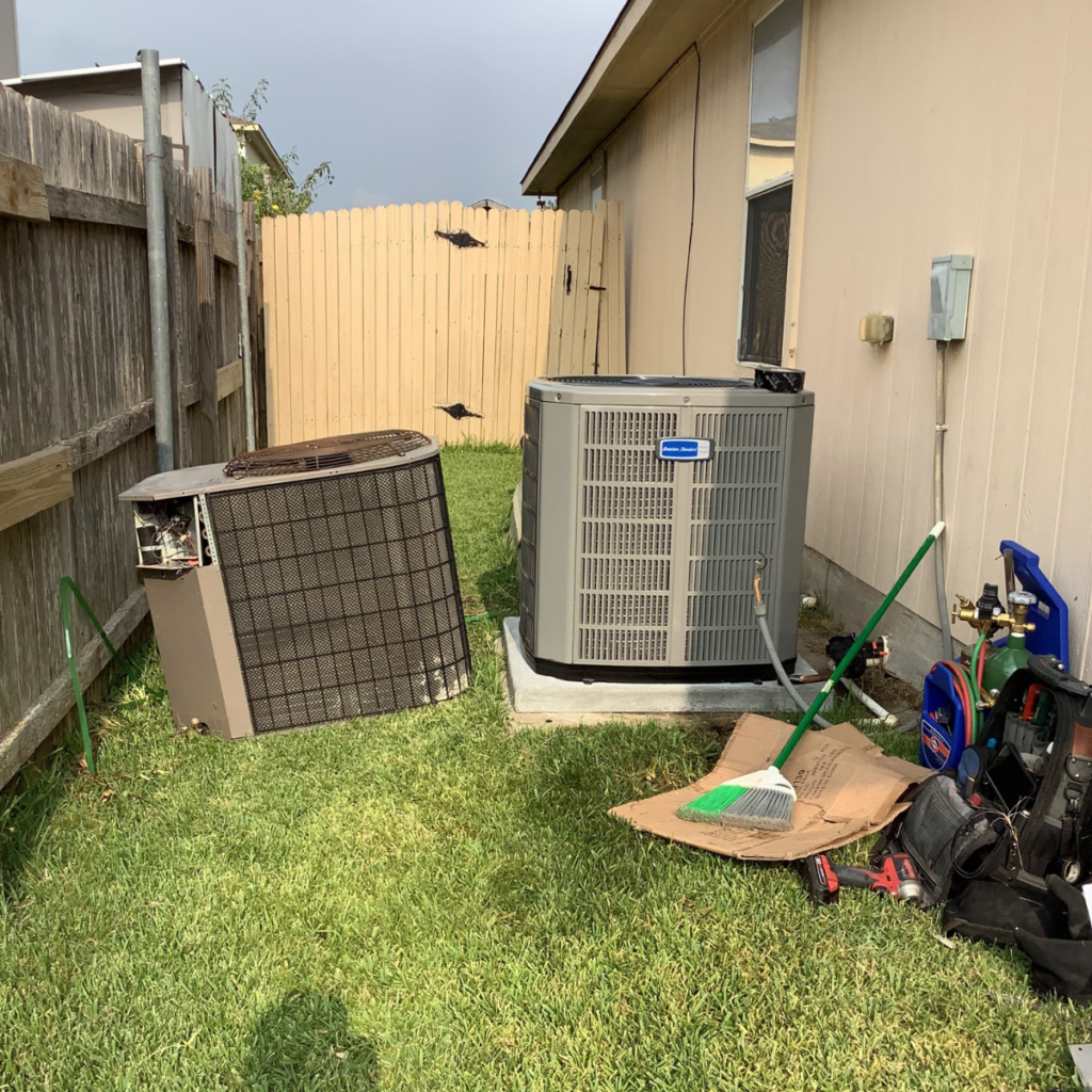 two outdoor hvac units sitting next to each other after being replaced with each other, one older and one newer system