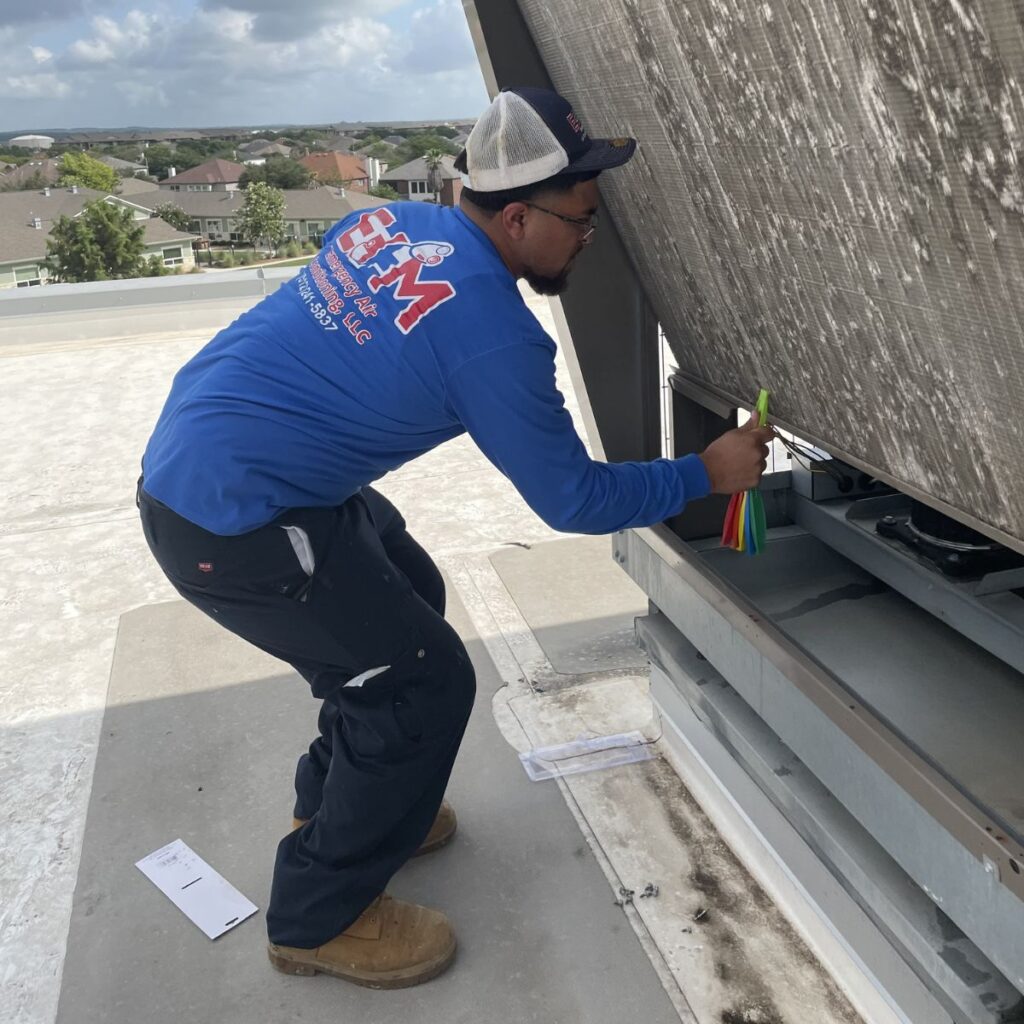 e+m emergency technician performing maintenance on a commercial unit
