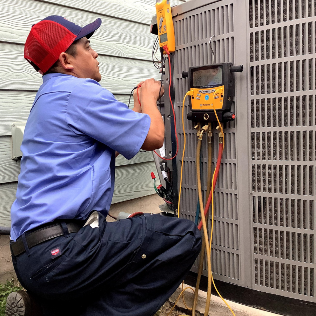 e+m emergency air conditioning technician performing ac maintenance on outdoor hvac system with digital pressure checker