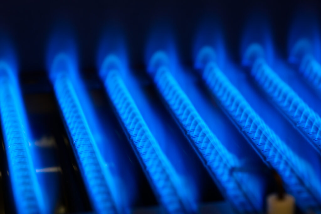 closeup of blue burning gas in gas furnace system